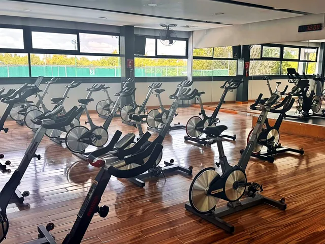 Salón de spinning con bicicletas y piso de madera